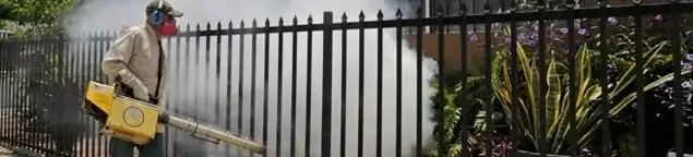 Mosquito control technician fogging a yard perimeter for mosquito reduction in El Paso, TX